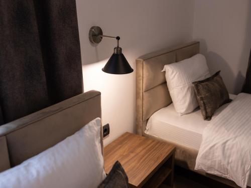 新帕扎尔Hotel RAS Pazarište的一间卧室配有一张床、一张桌子和一盏灯
