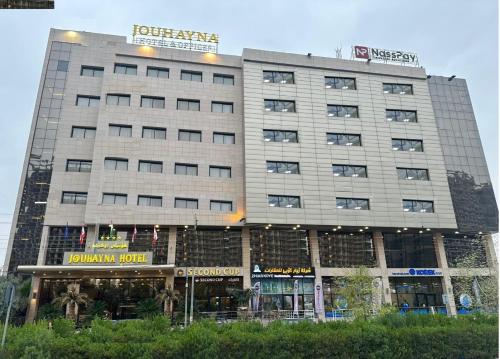 埃尔比勒Jouhayna Hotel&Suite的一座高大的建筑,上面有标志