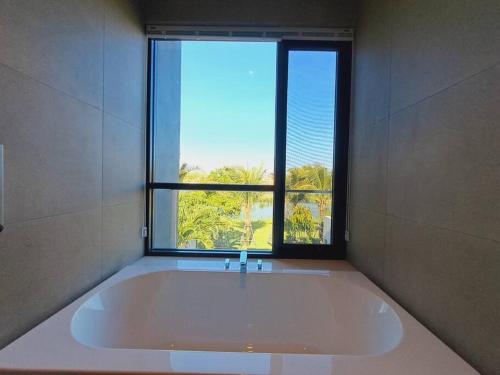 后川Sanctuary Ho Tram Villa的带窗户的浴室设有大浴缸