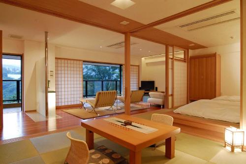 箱根箱根时之雫日式旅馆的卧室配有一张床和一张桌子及椅子
