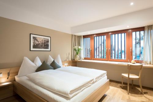 劳特阿赫Hotel Johann Lauterach的卧室设有白色大床和窗户。