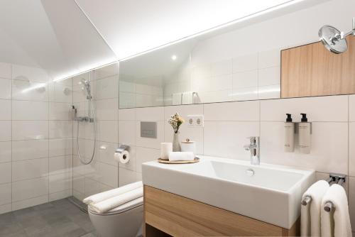 劳特阿赫Hotel Johann Lauterach的白色的浴室设有水槽和卫生间。