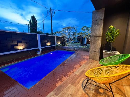 关丹LA Villa Private Pool Kuantan的一个带两把椅子和一张桌子的游泳池