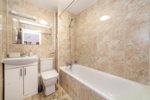 伦敦Lovely Studio Flat in Wimbledon w/ Free Parking的带浴缸、卫生间和盥洗盆的浴室