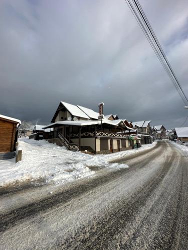 布克维Palaga Bukovel的房屋前有雪覆盖的道路