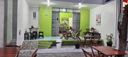 北茹阿泽鲁Pousada Point da Nanda的餐厅拥有绿色的墙壁和木桌及椅子
