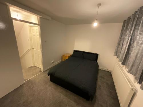 伦敦Spacious 2 bed Dulwich flat green views的一间卧室设有一张黑色的床和一个窗户。