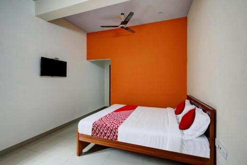 钦奈Simsan Inn的一间卧室配有一张橙色墙壁的床