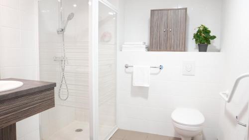 YzeureZenao Appart'Hotel的白色的浴室设有卫生间和淋浴。