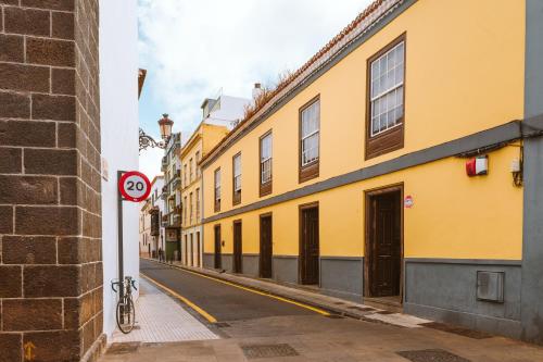 拉拉古纳Marhaba La Laguna, alojamiento en centro histórico de San Cristóbal de La Laguna的一条有黄色建筑和没有停车标志的街道