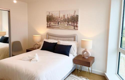 布拉克内尔Urban Gateway Spacious Apartment with free parking的卧室配有带两盏灯的白色床