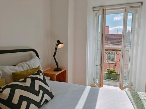 里斯本Jerónimos Apartments best place in Lisbon - 1º D的一间卧室设有一张床和一个美景窗户。