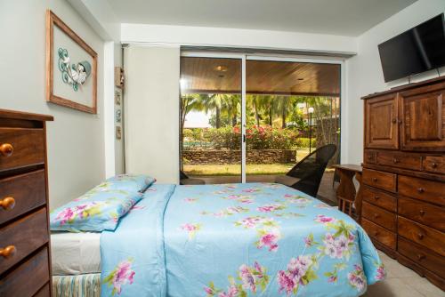 PampatarBellos apartamentos en Loma Real, Pampatar的一间卧室配有一张床、一个梳妆台和一扇窗户。