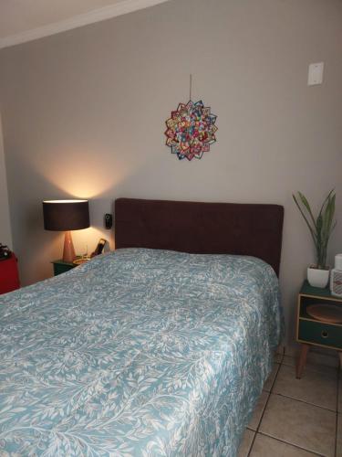 索罗卡巴Quarto com Cama de Casal的一间卧室配有一张带蓝色棉被的床