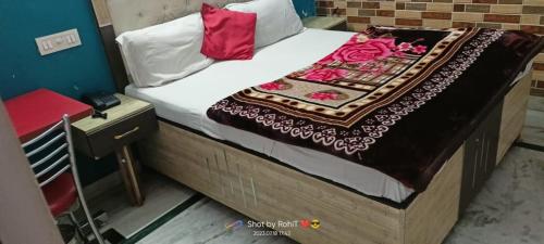 钱德加尔HOTEL NEW APPLE ROSE的一张带白色床单和红色枕头的床