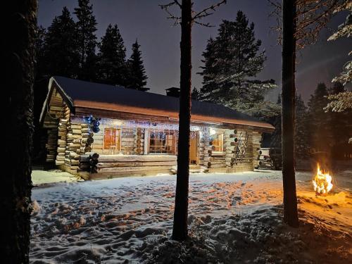 鲁卡Villa RukanKelo的雪中带圣诞灯的小木屋