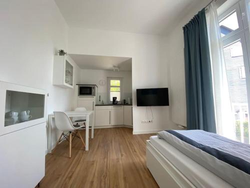 巴特拉斯费Apartment Nr. 2 Bad Laasphe Altstadt的一间带一张床和一张书桌的卧室和一间厨房