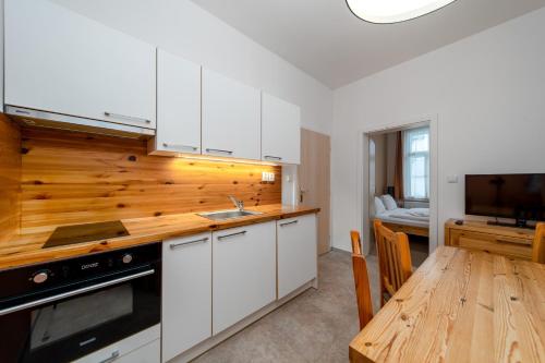 扬斯凯拉兹涅扬斯基波托克I.公寓的厨房配有白色橱柜和木桌