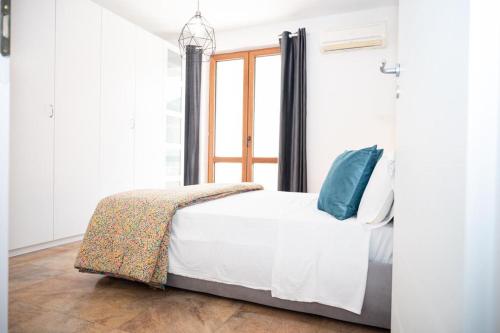 SianoRoom 500的一间卧室配有白色床和蓝色枕头