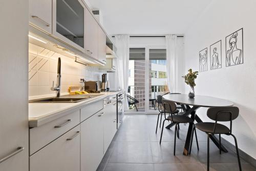 卢森堡Charming 1BR Apt w/ Terrace & 5 min Drive to City的白色的厨房配有桌椅