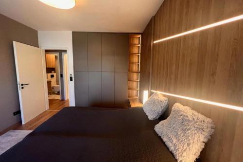 布达佩斯Glamorous Apartment in Budapest, Hungary的一间卧室配有一张黑色床和木墙