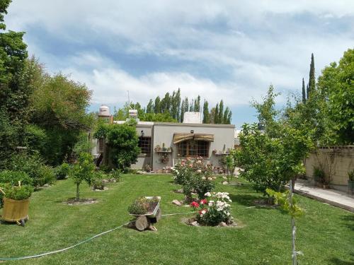 维斯塔尔巴TRANQUILO LOFT EN VISTALBA的一座带鲜花和树木的院子的房子
