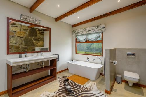 埃斯特科特Zulu Waters Game Reserve的带浴缸、水槽和斑马地毯的浴室