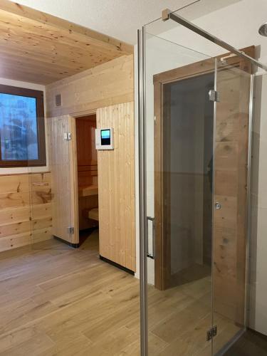 塔尔维西奥Golfchalet 3 confini的木墙客房内的玻璃淋浴间