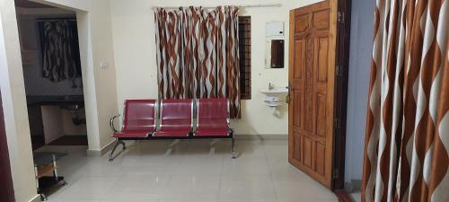 古鲁瓦尤尔Guruvayur Adithya的红色椅子坐在有门的房间