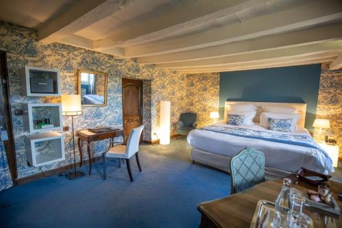梅屈埃斯梅屈埃斯城堡酒店的一间卧室配有一张大床、一张桌子和一张桌子