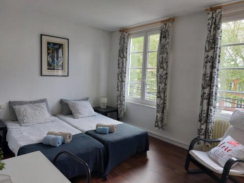 里尔沃邦套房公寓酒店的一间卧室设有两张床、一把椅子和窗户。