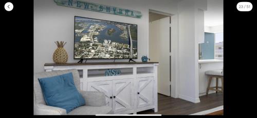 新士麦那海滩Coastal Waters 209的客厅配有桌子上方的电视