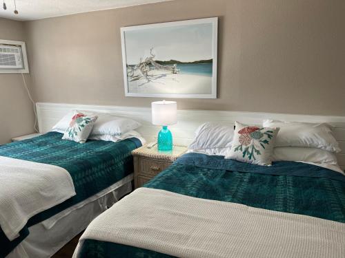 新士麦那海滩Coastal Waters 209的一间卧室设有两张床和一张桌子上的台灯。