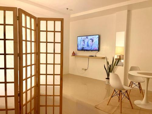 杜马格特Japandi-inspired Hideaway的一间带电视和桌子的客厅