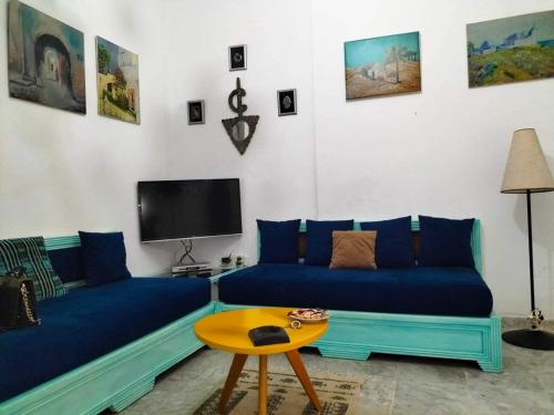 Chott MeriemDans résidence à bord de la mer avec plage privée的客厅配有蓝色的沙发和电视