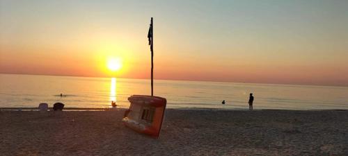 Chott MeriemDans résidence à bord de la mer avec plage privée的海滩上的椅子,背靠日落