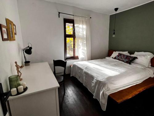VrtovacSentina kuća的一间卧室配有一张床、一张书桌和一个窗户。