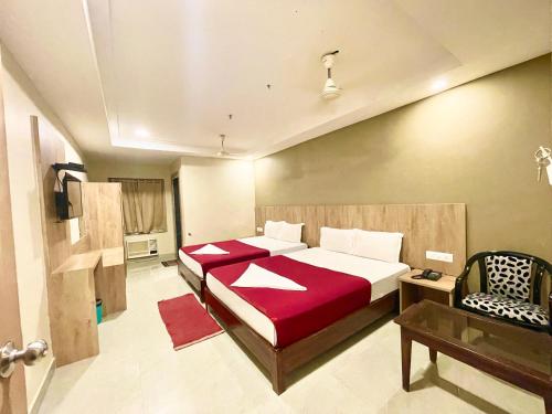 普里Hotel Janaki Pride, Puri fully-air-conditioned-hotel spacious-room with-lift-and-parking-facility的一间卧室配有一张床和一把椅子