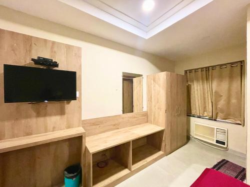 普里Hotel Janaki Pride, Puri fully-air-conditioned-hotel spacious-room with-lift-and-parking-facility的客厅设有壁挂式平面电视。