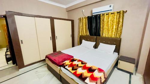 海得拉巴Prince Castle-4BHK Apartment,Guesthouse的一间卧室配有白色床单和黄色窗帘