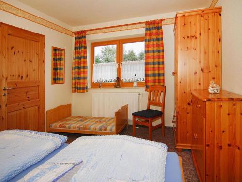 LütowApartment house, Lütow的一间卧室设有两张床、一把椅子和一个窗户。