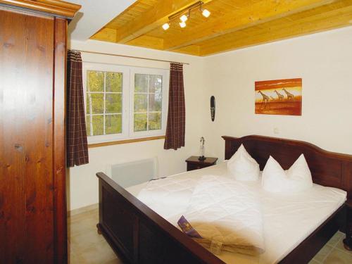 特拉森海德Semi-detached house Strandhaus II, Trassenheide的一间卧室配有一张带白色床单的大床