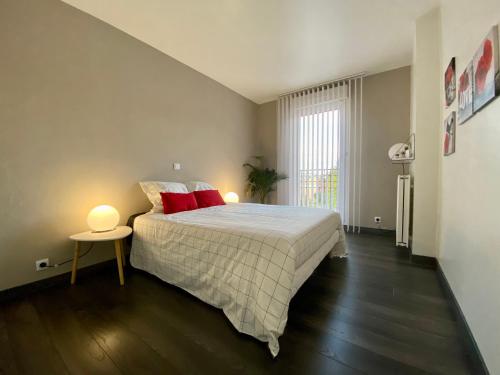 伊兰柯尔特Appartement terrasse proche Versailles的一间卧室配有一张带红色枕头的大床