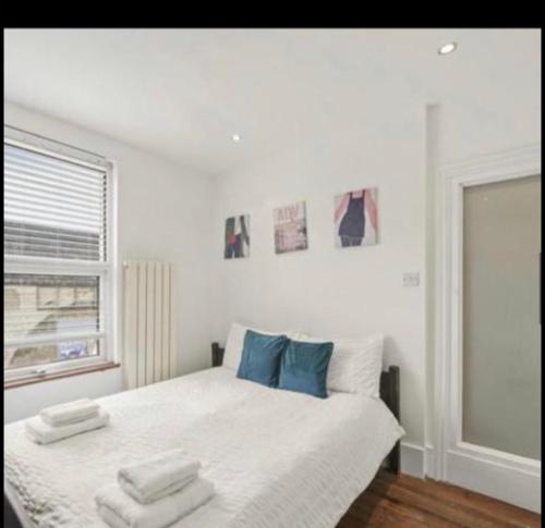 伦敦Luxury city centre Apartment的白色卧室配有蓝色枕头的床