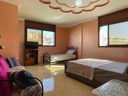 依索安Villa de l'ermitage的一间卧室设有两张床、一台电视和窗户。