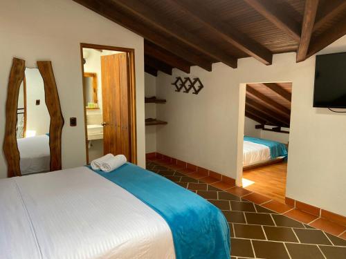 莱瓦镇HOTEL ENCANTO COLONIAL的一间卧室配有两张床和一台平面电视