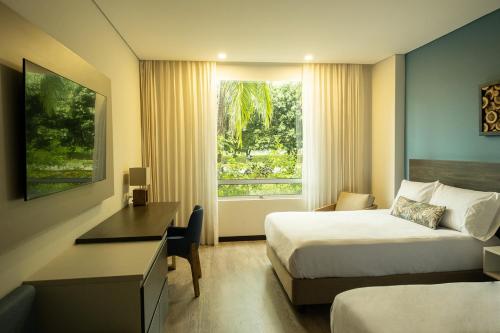 约帕尔Hotel Morúa的酒店客房设有两张床、一张书桌和一个窗户。