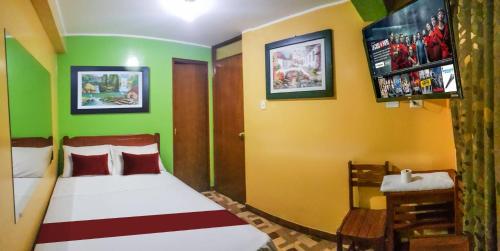 利马Hospedaje Escorpio的一间卧室设有一张带绿色和黄色墙壁的床。