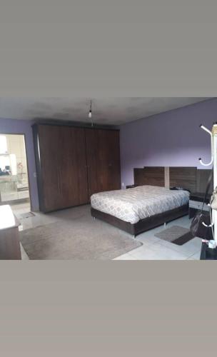 São Gonçalo do AmaranteSítio casa grande的一间卧室配有一张床和紫色的墙壁