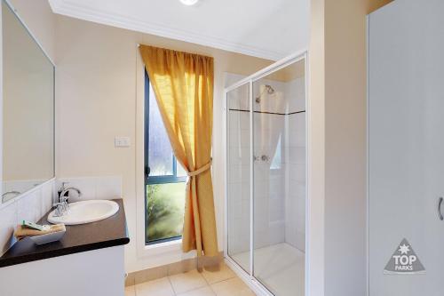 托克姆沃尔布莫雷韦旅游公园酒店的带淋浴和盥洗盆的白色浴室